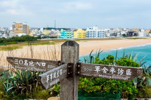 a wooden sign with a beach in the background at Beachcastle & Sea View Villa in Magong