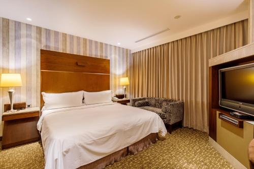 a hotel room with a bed and a television at Hotel HD Palace in Taipei