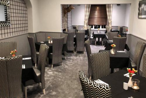 a restaurant with tables and chairs in a room at Haughton Arms Hotel in Alford