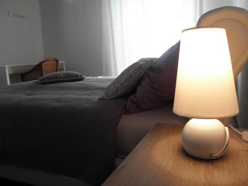 a lamp on a wooden table next to a bed at Apartment-rooms Preka in Rab