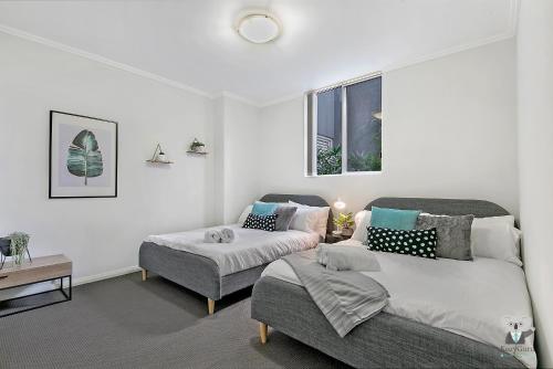 um quarto com 2 camas, um sofá e uma janela em WARRICK FRAM 3 BEDS APT FREE PARKING WALK TO WESTFIELD CLOSE TO HOSPITAL NWF003 em Warwick Farm