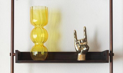 a shelf with two glass vases and a hand statue at MAMAKA by Ovolo in Kuta