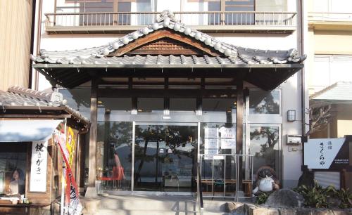 un negozio di fronte a un edificio con tetto asiatico di Sakuraya a Miyajima