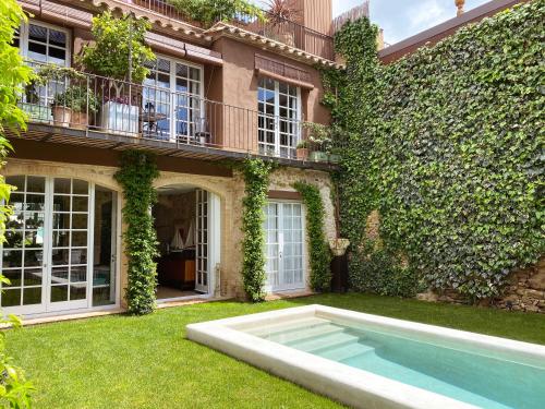 uma casa com piscina no quintal em Llimona Suites - Adults Only em Corçà