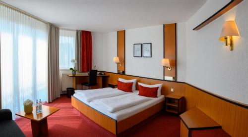 a hotel room with a bed and a desk at Hotel am Wasserfall in Lingen