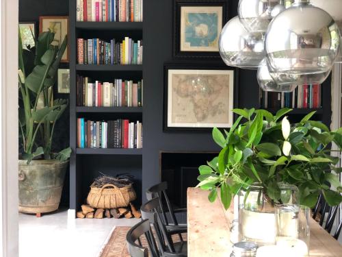 a dining room with a table and a book shelf with books at Llimona Suites - Adults Only in Corsá