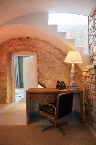 an old desk with a chair and a lamp at Llimona Suites - Adults Only in Corsá