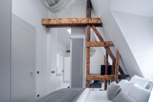 Habitación con paredes blancas, muebles blancos y vigas de madera. en Wilda Nova en Poznan