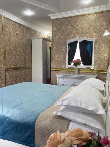 a bedroom with a bed with blue sheets and pillows at Lion Hotel in Astana