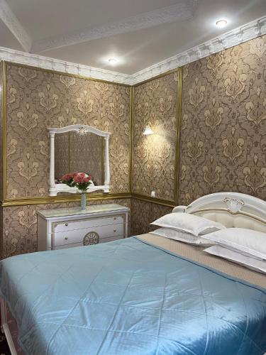 a bedroom with a blue bed and a mirror at Lion Hotel in Astana