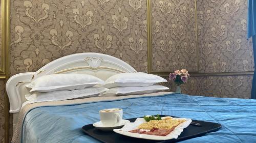 a tray with a plate of food on a bed at Lion Hotel in Astana
