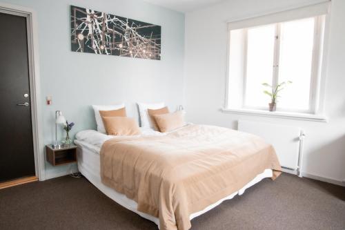 a white bedroom with a large bed with pillows at Bernstorff Castle Hotel in Gentofte