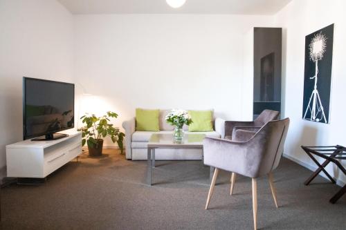 a living room with a couch and a tv at Bernstorff Castle Hotel in Gentofte