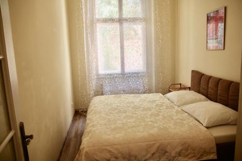 mała sypialnia z łóżkiem i oknem w obiekcie Apartman Sylva na Staré Louce 42 w Karlowych Warach