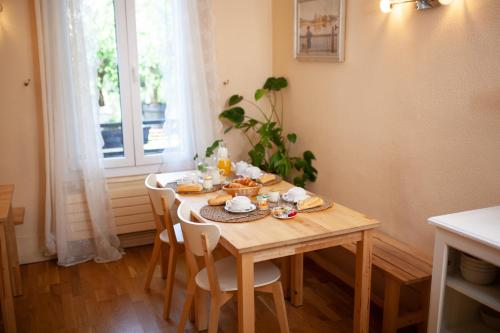 un tavolo in legno con cibo sopra in una stanza con finestra di Hôtel du Parc a Choisy-le-Roi