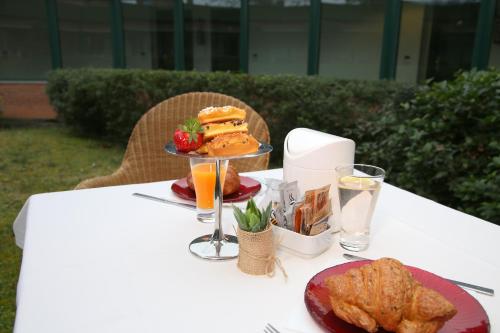 Phi Hotel Emilia في أوتْسانو ديل إميليا: طاولة بيضاء عليها طبق من الطعام