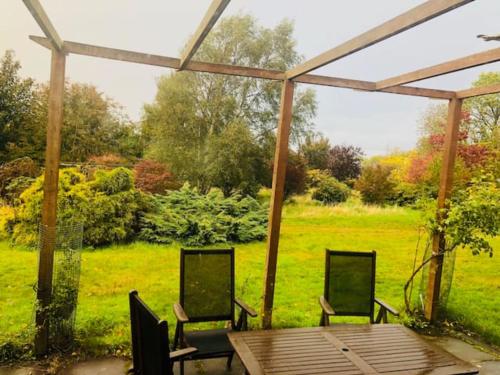 a patio with a table and chairs and a field at Home Comforts in Peaceful 2 Acres in Inverness