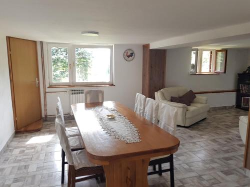 a living room with a wooden table and chairs at Kuća za odmor Mažuran in Karlovac