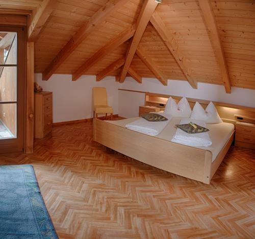 a bedroom with a bed and a wooden ceiling at Siganatenhof in Caldaro