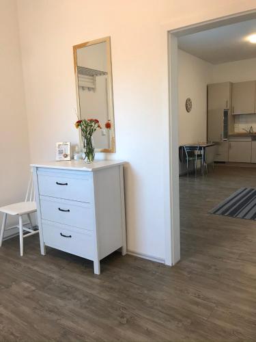 a dresser with a mirror and a vase with flowers on it at Ferienwohnung I in Papenburg