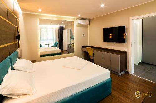 um quarto de hotel com uma cama e uma televisão em Hotel Saftica em Săftica