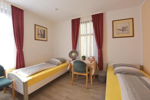 1 dormitorio con 2 camas, mesa y escritorio en Weisser Brunnen en Gotha
