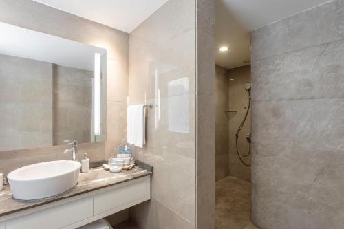 a bathroom with a sink and a mirror and a shower at Paloma Oceana in Side