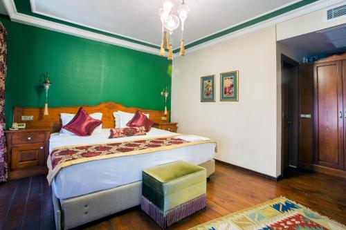 a bedroom with a large bed with a green wall at Garden House Hotel - Special Class in Istanbul