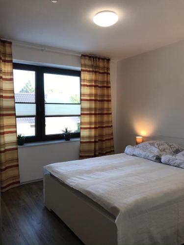 a bedroom with a bed and a large window at Ferienwohnung I in Papenburg