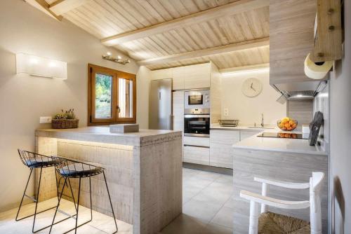 a kitchen with a counter and stools in it at MONTELIA Ático El Ciervo de Panticosa in Panticosa