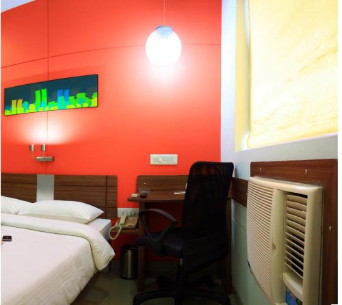 a room with two beds and a desk with a chair at Ginger East Delhi in New Delhi