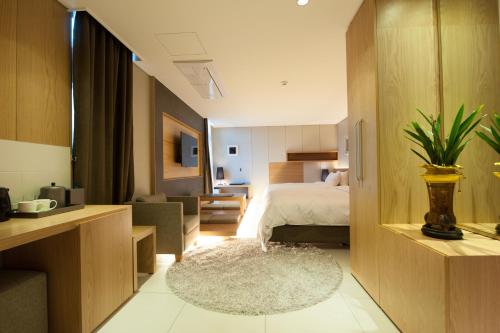 فندق ريان في سول: غرفة نوم مع سرير وغرفة معيشة