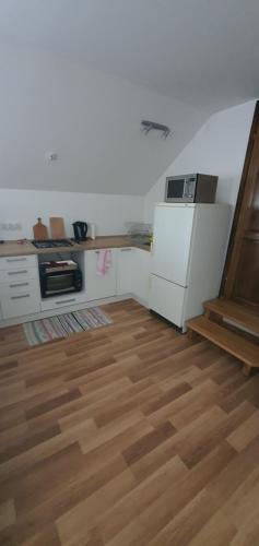 a kitchen with a wooden floor and a refrigerator at Nocleg U Jagódki in Zubrzyca Dolna