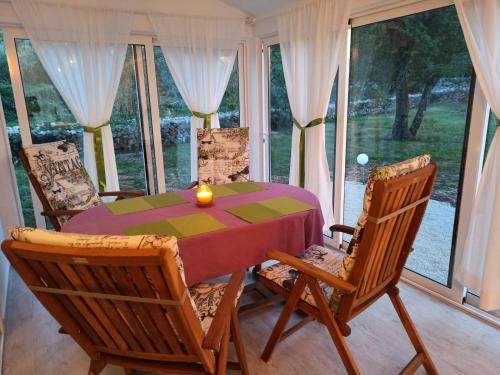 a dining room table and chairs with a candle on it at Holiday House Vela Vrta in Sveti Ivan Dobrinjski