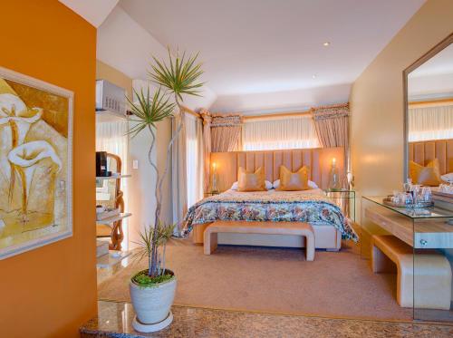 a bedroom with a large bed and a table at Xanadu Guest Villa in Wilderness