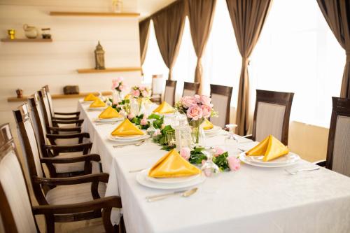 a long table with white table cloths and flowers at Ewan Ajman Suites Hotel in Ajman 