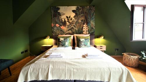 a bedroom with a large bed with a painting on the wall at The George Rooms - Boutique Style in Würzburg