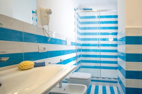 a blue and white bathroom with a tub and a toilet at LEONE ROSSO APARTMENTs in Sorrento