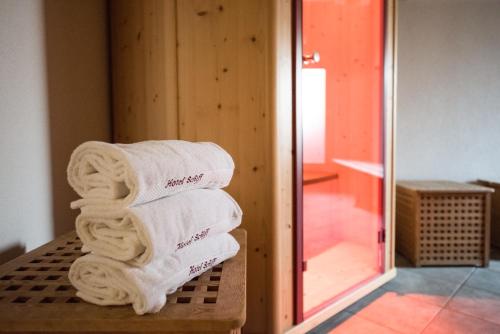 einen Stapel Handtücher auf einer Bank in einem Zimmer in der Unterkunft Hotel Schiff am Schluchsee in Schluchsee