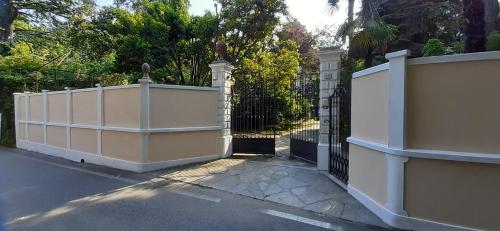 una recinzione bianca con un cancello su una strada di B&B Villa Margherita a Lesa