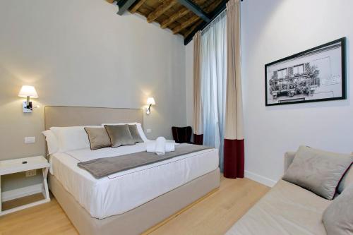 een slaapkamer met een groot wit bed en een bank bij Monti Panisperna suites in Rome