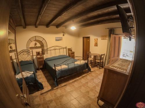 a bedroom with two beds and a table at Albergo Diffuso Borgo Santa Caterina "Quartire Hebraic" in Castiglione di Sicilia