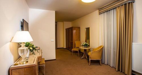 a hotel room with a hallway with a table and chairs at Confero Nowa Baśń in Nysa