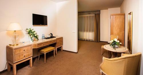 a hotel room with a desk and a television at Confero Nowa Baśń in Nysa