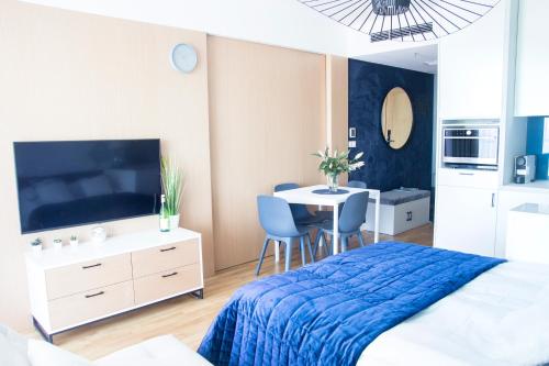 Schlafzimmer mit einem Bett und einem Tisch mit Stühlen in der Unterkunft Apartament z widokiem na morze SEASIDE 208 AL-DOM in Kołobrzeg