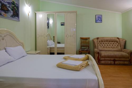a bedroom with a bed with a chair and a couch at White House Apartments in Odesa