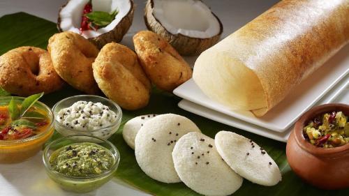 a table topped with bread and various types of food at Kumaran Millenium Residency in Vellore