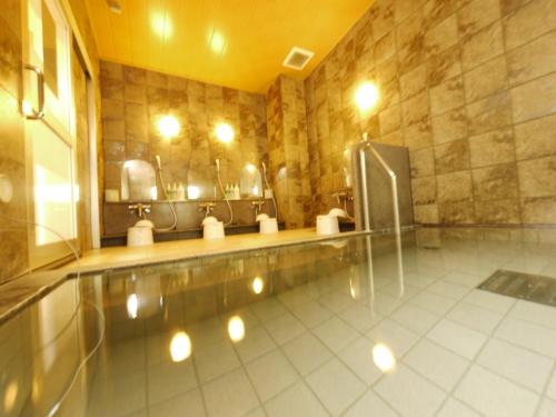 a bathroom with a urinal and a sink at Hotel Route-Inn Shibukawa in Shibukawa