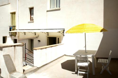 a table and chair with an umbrella on a balcony at Fardella 250 in Trapani