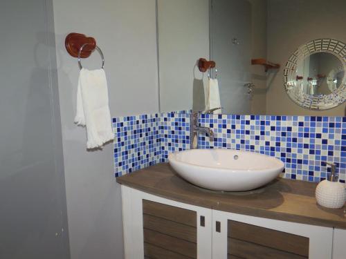 a bathroom with a white sink and a mirror at Goose Valley Retreat with Sea Views in Plettenberg Bay